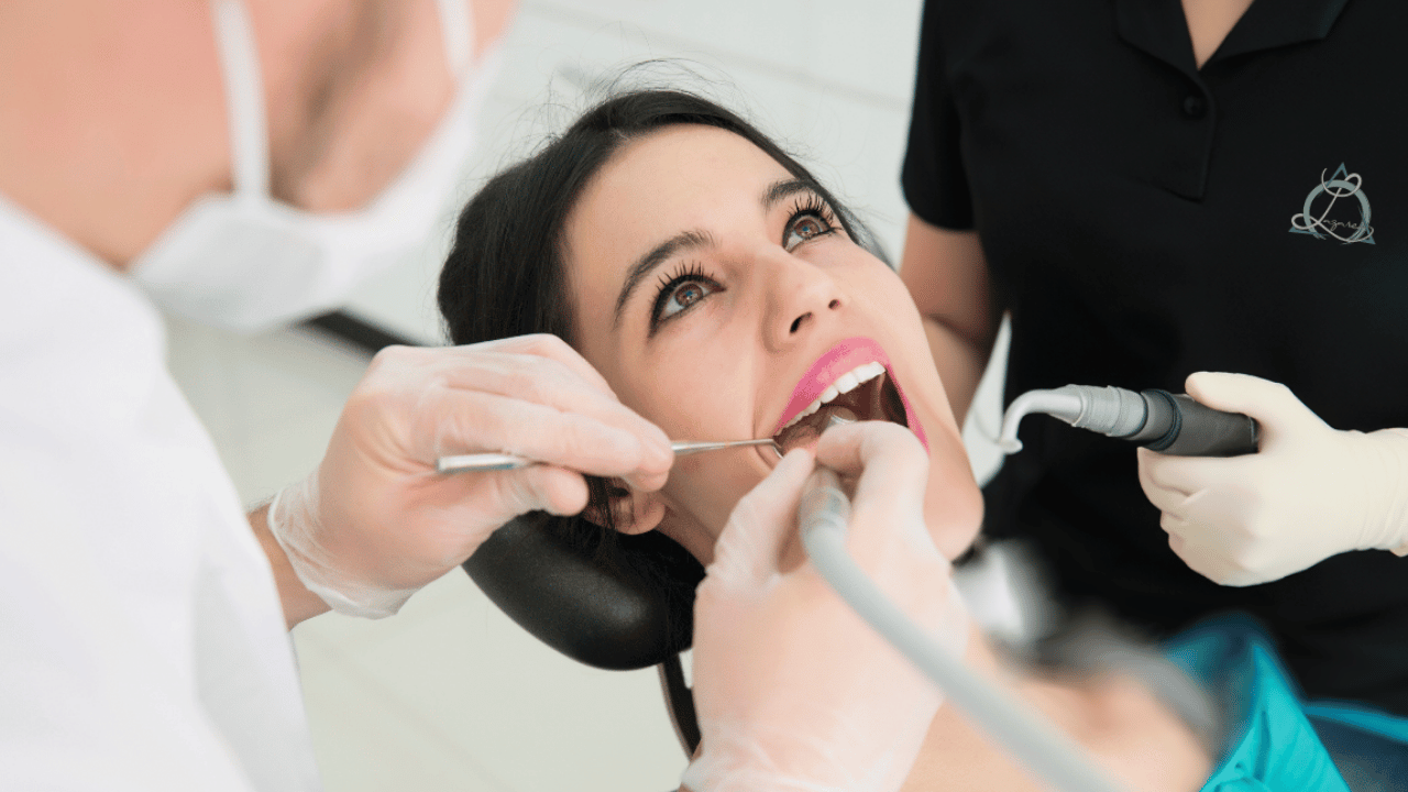 A dental hygienist performing a professional teeth cleaning on a patient, ensuring optimal oral health through regular maintenance and care.